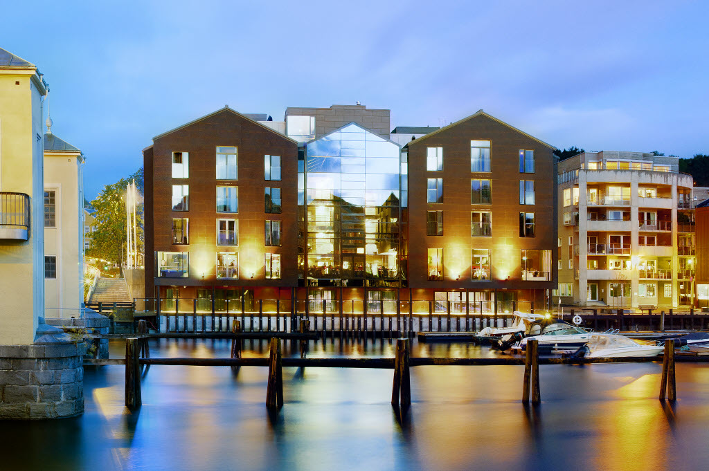Hotellfasade i kveldsbelysning sett fra Nidelven, Scandic Bakklandet